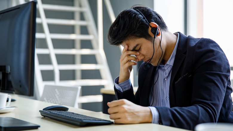 Exhausted man with phone headset