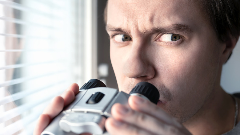 Paranoid man spies on neighbors