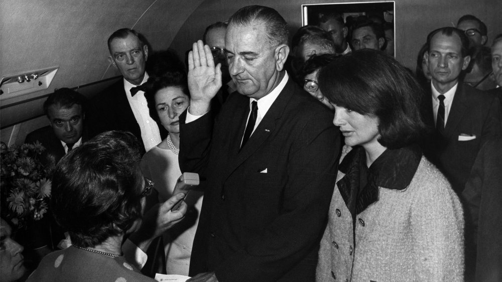 Judge Sarah Hughes, Lady Bird Johnson, President Lyndon B. Johnson and Jackie Kennedy in front of various other important people at Johnson's swearing in on Air Force One, November 22, 1963, by Cecil W. Stoughton