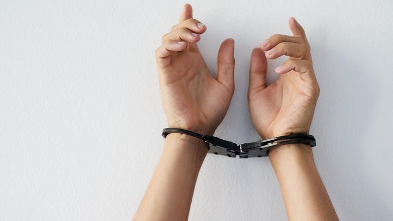 Cuffed hands against a white background