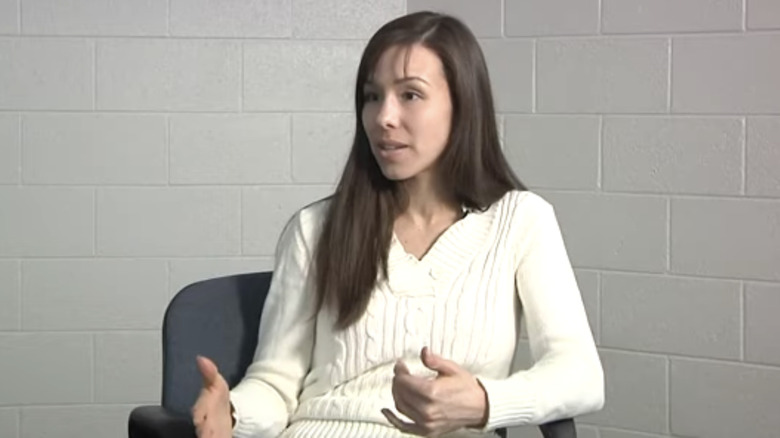 Jodi Arias speaking white cardigan white brick wall