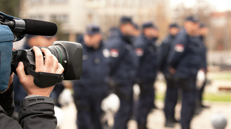 Cameraman filming police officers