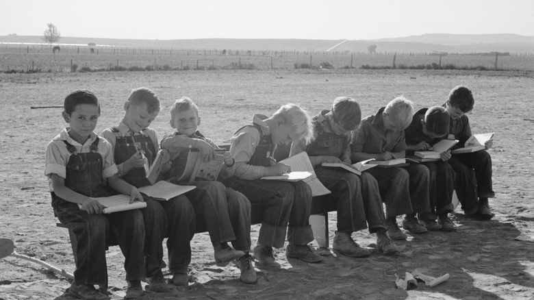 Line of children writing outdoors