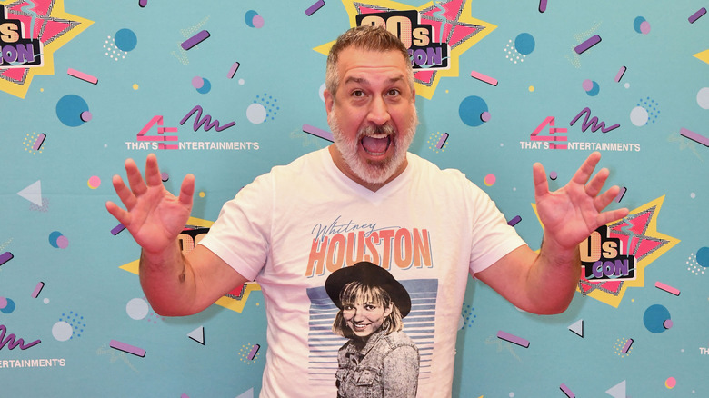 Joey Fatone smiling with hands raised