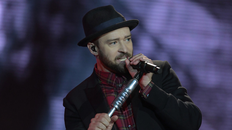 Justin Timberlake on stage in dark hat and tartan shirt