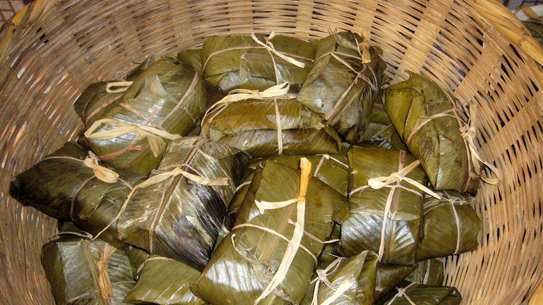 A basket of tamales wrapped in maxan leaves.