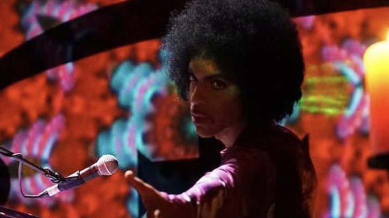 prince reaching out to audience member from piano during 2016 concert