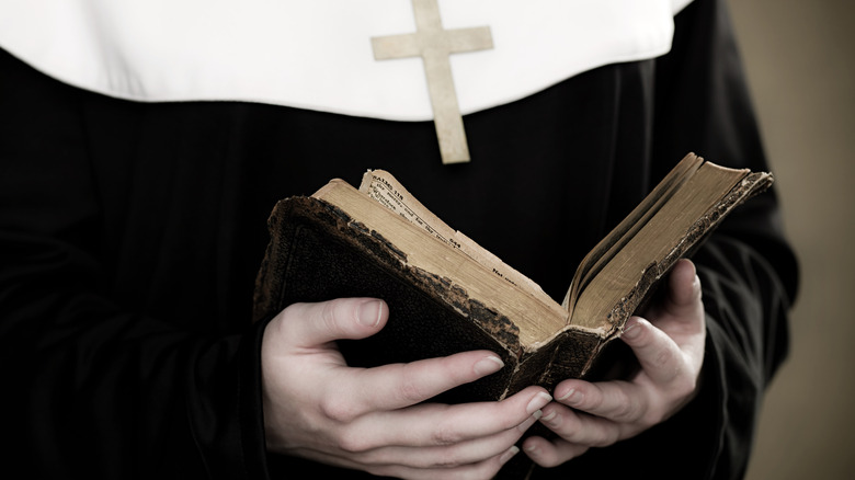 nun holding bible cross