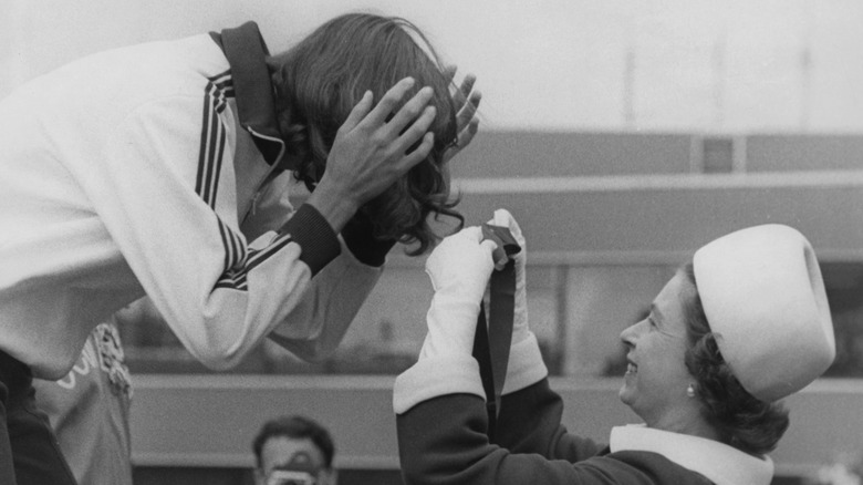 Not meant for hairdressing: Queen Elizabeth untangles a ribbon from a girl's hair