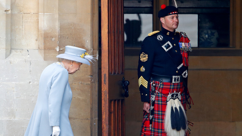 The queen enters and her piper, Richard Grisdale, stands at attention