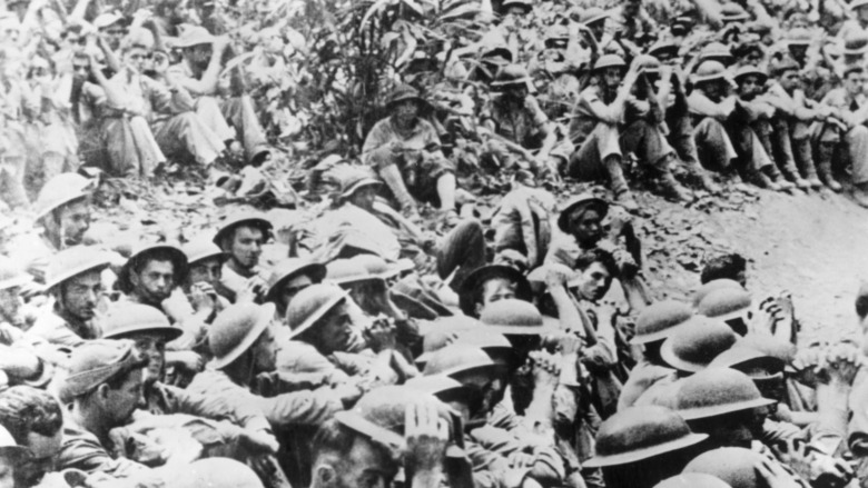 Filipino and American soldiers sitting on ground