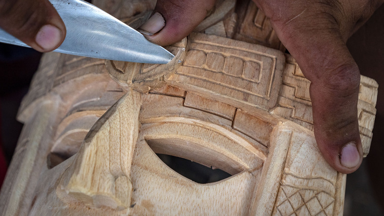 Local craftsman carving a mayan mask