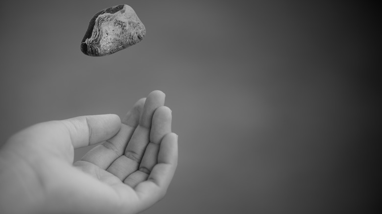 Hand tossing rock
