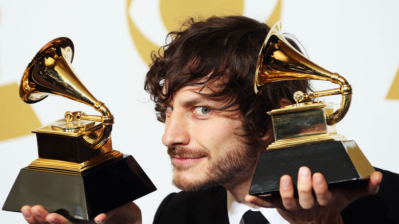 Gotye holding two Grammys