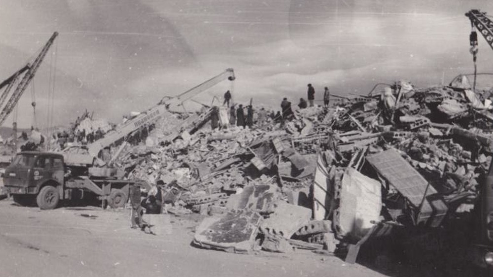 People standing atop rubble in aftermath of the earthquake