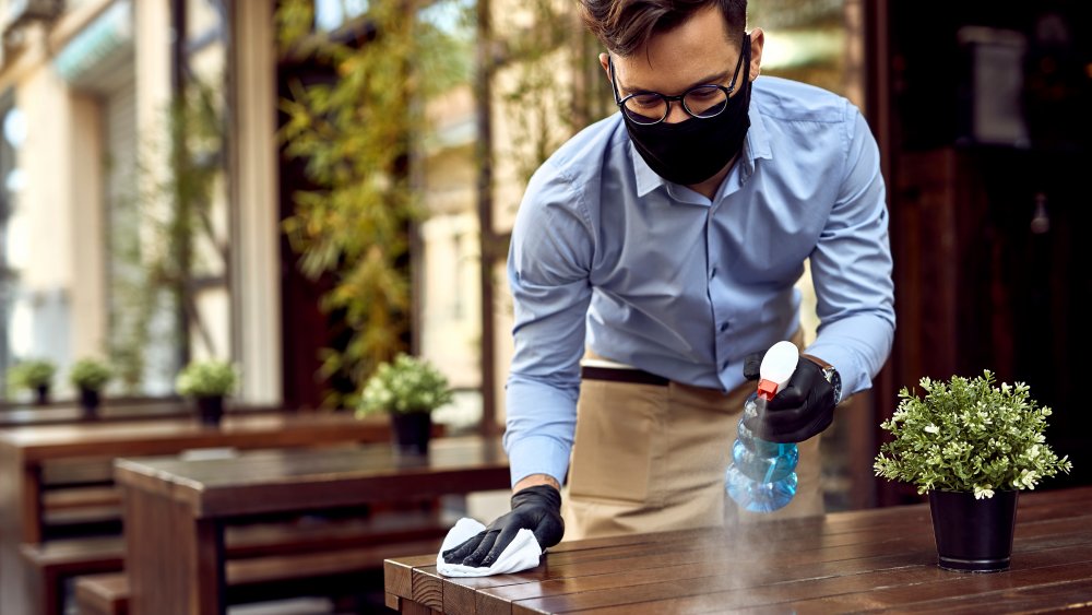 A man disinfecting a table 