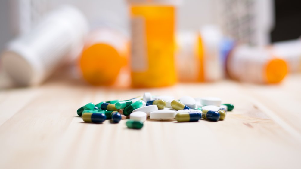 Assortment of pharmaceutical drugs with pill bottles in the background.