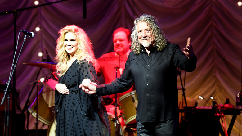 Alison Krauss and Robert Plant holding hands onstage