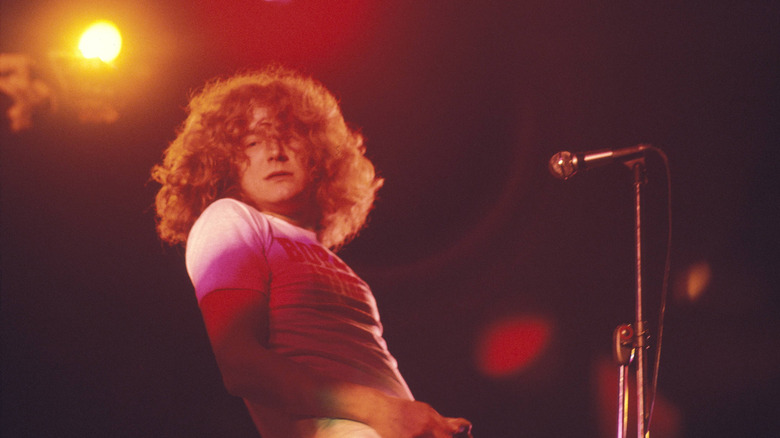 Robert Plant onstage at microphone in white T-shirt