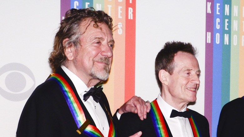 Robert Plant and John Paul Jones in suits with medals from Kennedy Center