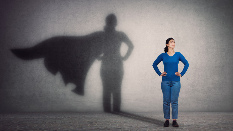 Woman in front of superhero shadow