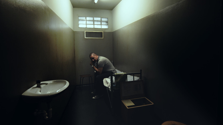 man sitting in solitary confinement cell