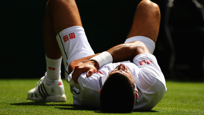 Djokovic clutching arm in injury