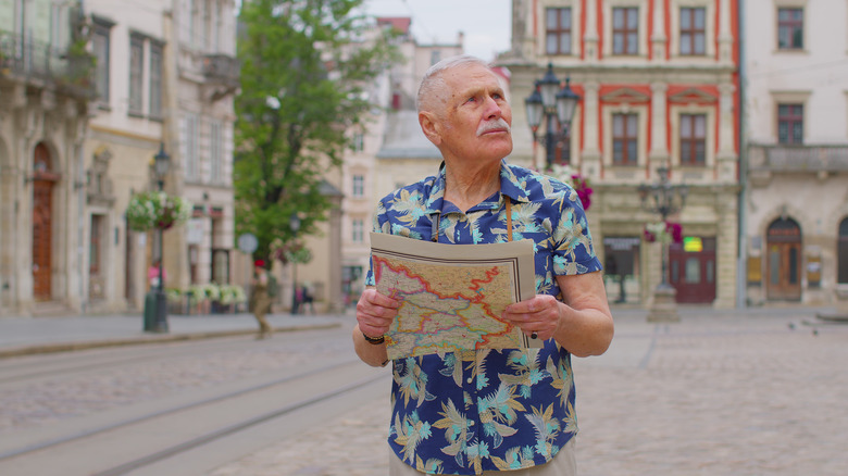 Man looking for his way holding a paper map