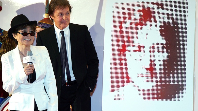 Paul McCartney and Yoko Ono next to a photo of John Lennon