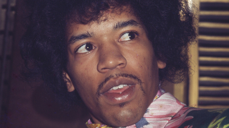 Jimi Hendrix looking to his left in a flowery shirt