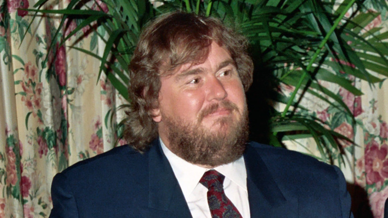 Bearded John Candy wearing a suit and tie