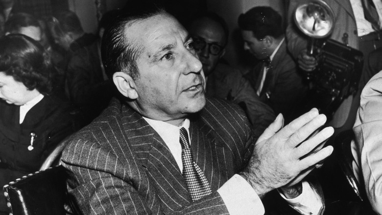 Frank Costello clasping hands in suit