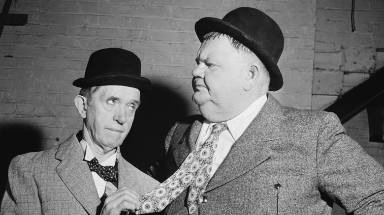 Stan Laurel holding Oliver Hardy's tie 