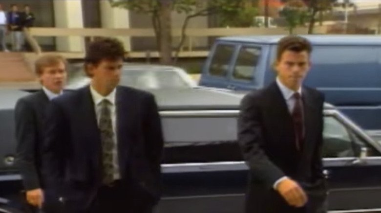 Menendez brothers in suits leaving vehicle