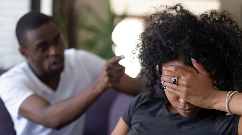 Man angrily pointing finger at woman