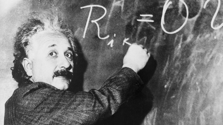 Albert Einstein writing on chalk board 