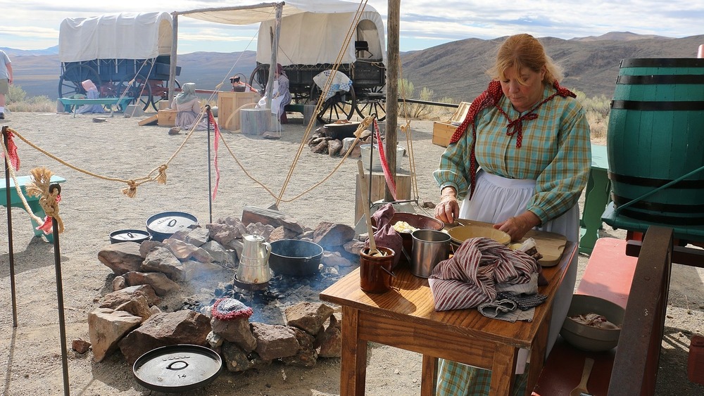 oregon trail camp reenactment with woman cooking