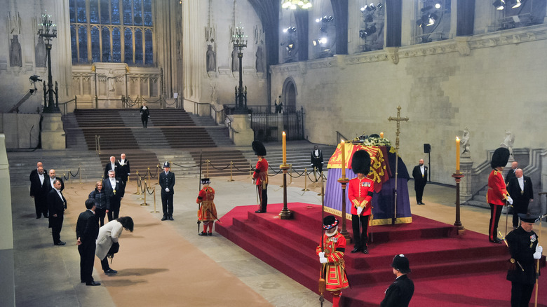 Sima Mansouri bows to the queen's coffin 