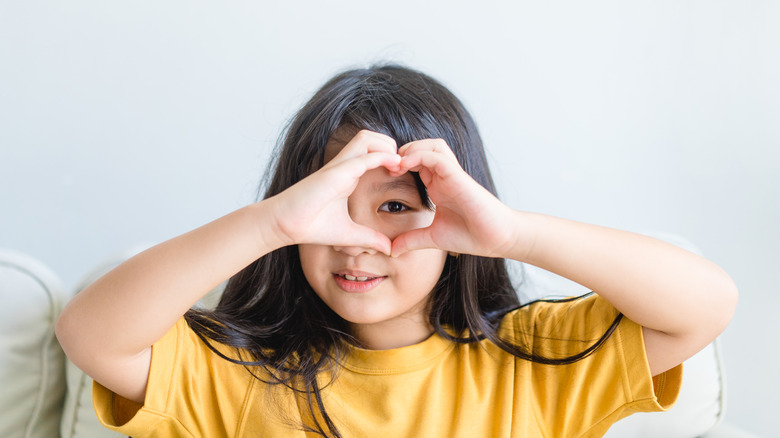 small child hands over eye