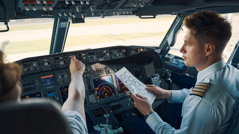 Co-pilot holding paper sitting in cockpit