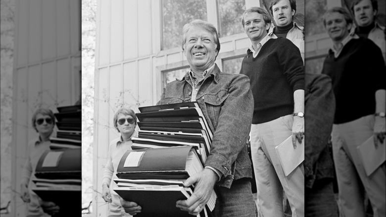 Jimmy Carter smiling carrying files