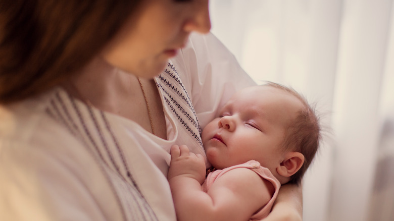 Sleeping newborn in woman's arms