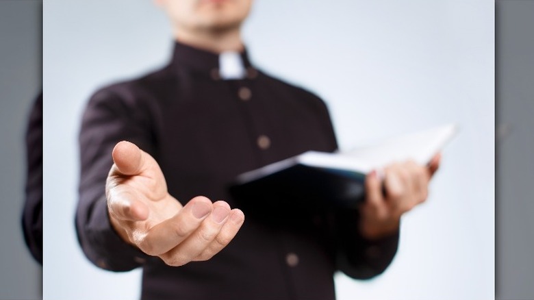 Priest with hand outstretched