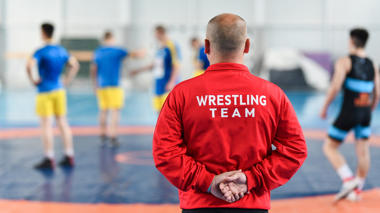 Wrestling coach red jacket watching team