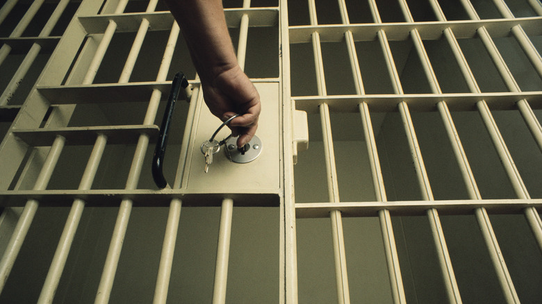 Guard putting key into prison cell lock