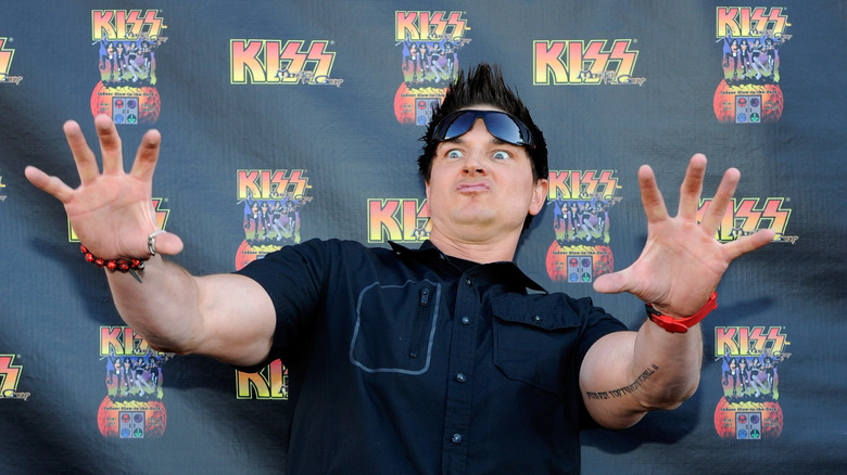 Zak Bagans sunglasses on head holding out arms silly expression