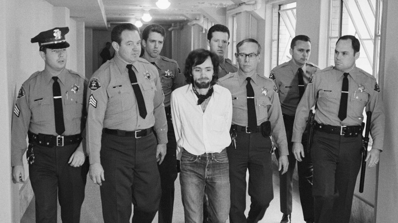 police walking wit Charles Manson hands behind back