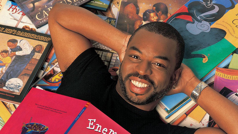 LeVar Burton lying on a pile of books