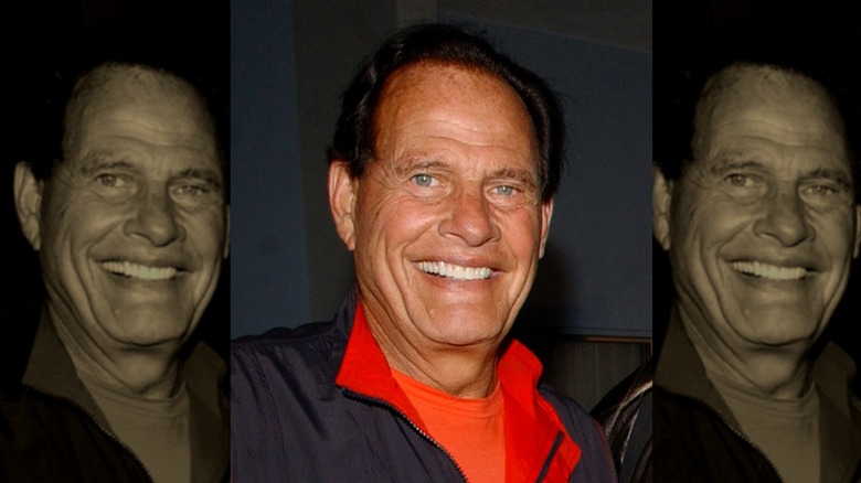 Ron Popeil In a red shirt and black jacket smiling