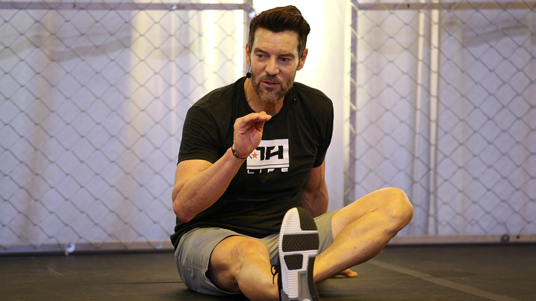 Tony Horton wearing a headset leading a fitness session